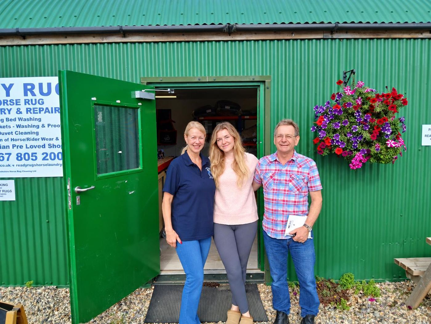 Kathy with two visitors outside the open door of the Ready Rugs workshop