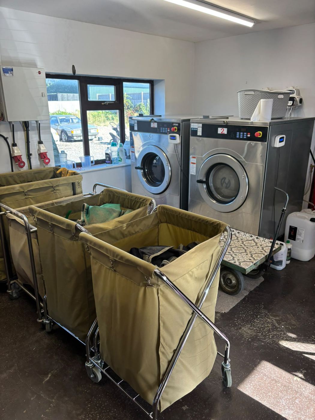 Commercial washing machines and laundry trolleys in the Ready Rugs workshop