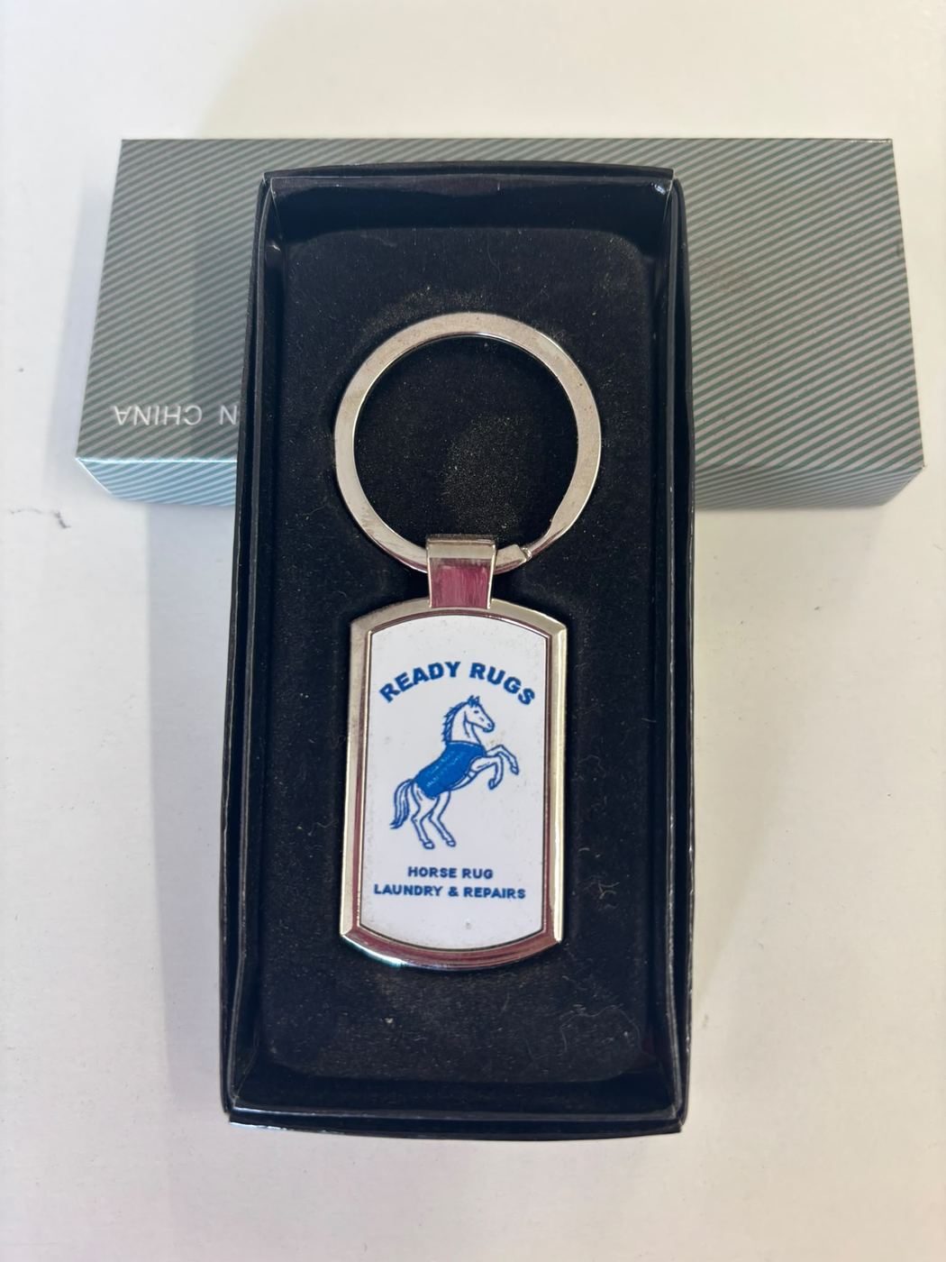 Boxed metal keyring printed with the Ready Rugs logo