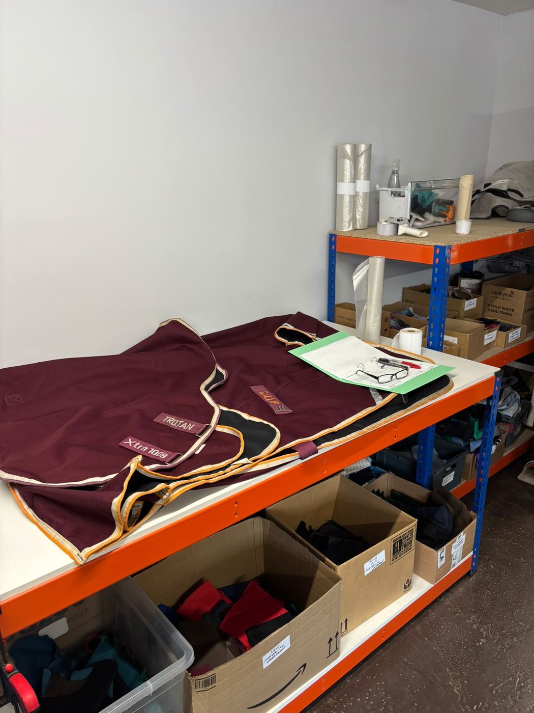 Washed rugs folded on shelving ready for collection